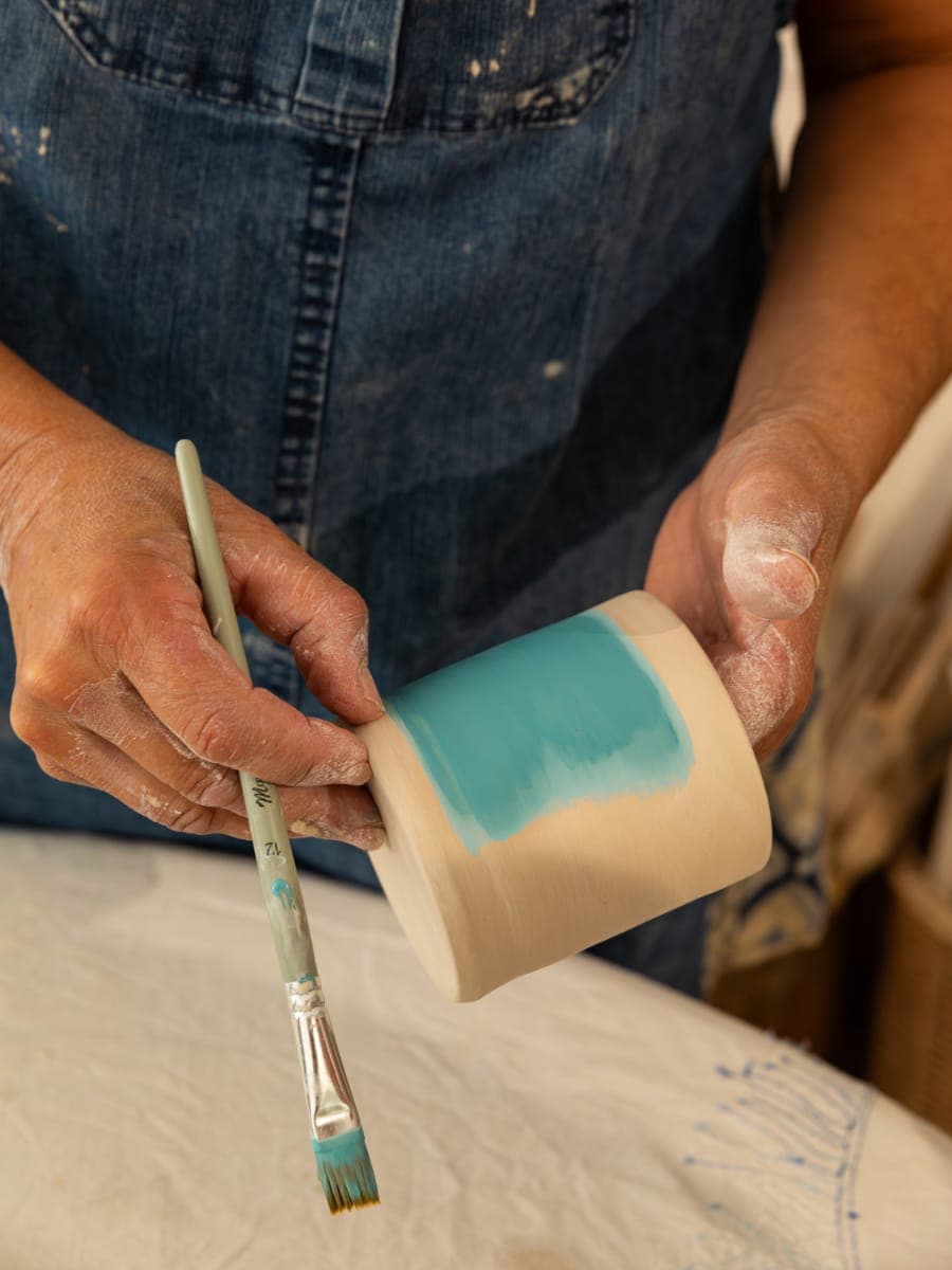 Craftswoman shaping clay on a potter's wheel